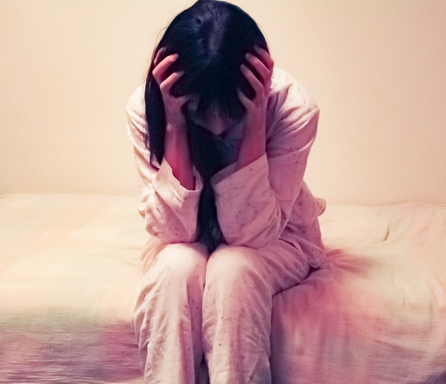 頭を抱える女性の写真
